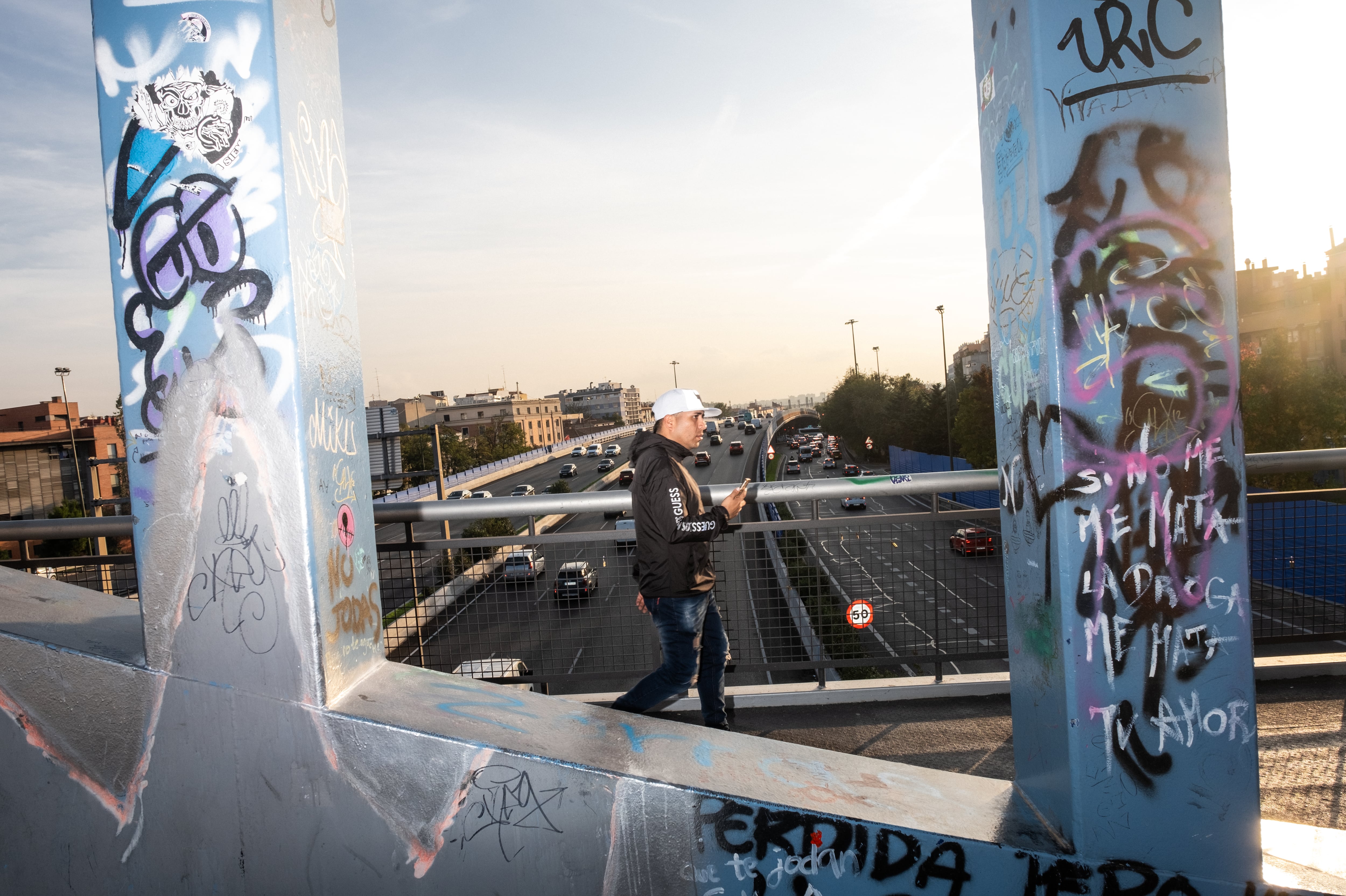 Un hombre atraviesa la pasarela de Valderribas, que une el distrito de Retiro con el de Puente de Vallecas.