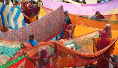 Mujeres tienden saris en Allahabad (India) durante el Kumbhamela, fiesta en la que las multitudes se bañan en el río sagrado.