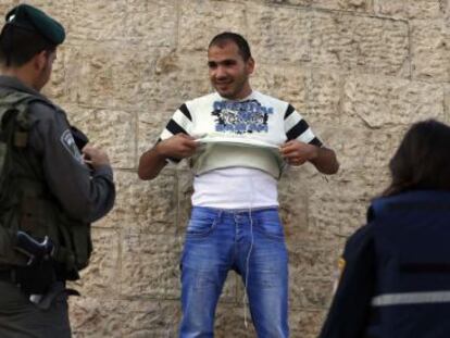 Policiais revistam palestino no Portão de Damasco, em Jerusalém.