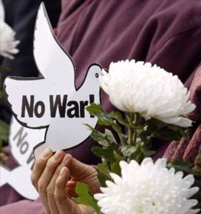 Una manifestante porta una paloma de la paz y una flor blanca durante una de las protestas llevadas a cabo en Corea del Sur contra el inicio de la guerra en Irak.