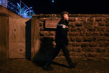 Las tumbas se encontradon profanadas, horas antes de que los legisladores adoptaran una resolución que equiparara el antisionismo con el antisemitismo. En la imagen, un gendarme custodia la entrada del cementerio.