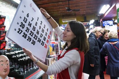 Una dependenta posa a la venda un dels calendaris.