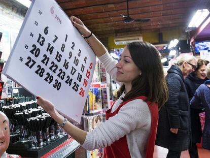 Una dependenta posa a la venda un dels calendaris.