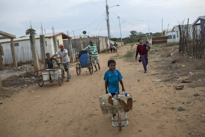 Residentes del barrio Villa Esperanza transportan en carretillas envases con agua potable. La resignación se respira en toda la ciudad, que antes de que se disparara el éxodo hacia Colombia, tenía más de dos millones de habitantes.