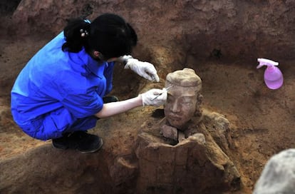 Una arqueóloga china trabaja en la limpieza de uno de los nuevos guerreros de terracota recién descubiertos en Xian, el julio pasado.