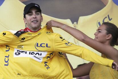 Una azafata del Tour entrega el maillot de amarillo a Gallopin.