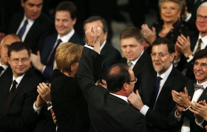 Hollande y Merkel levantan sus manos, tras ser mencionados en el discurso de entrega del Nobel de la Paz a la UE.