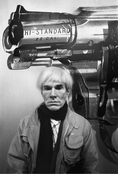 Andy Warhol posa delante de una de sus obras, un revólver,  en la galería Fernando Vijande de Madrid, el 16 de enero de 1983.