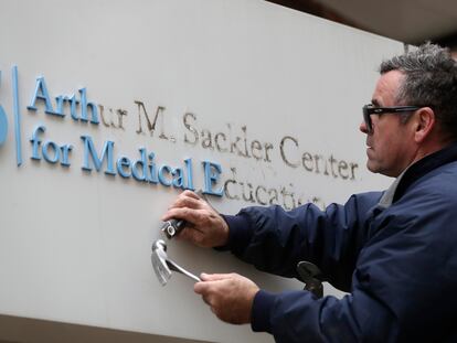 Un operario quita el nombre del mecenas  Arthur M. Sackler de la entrada a la Tufts School of Medicine de Boston en diciembre de 2019.