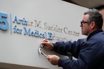 Un operario quita el nombre del mecenas Arthur M. Sackler de la entrada a la Tufts School of Medicine de Boston en diciembre de 2019.