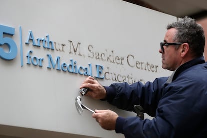 Un operario quita el nombre del mecenas  Arthur M. Sackler de la entrada a la Tufts School of Medicine de Boston en diciembre de 2019.