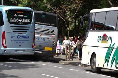 Turistas caminan junto a varios autocares, en Barcelona, en una imagen de archivo.