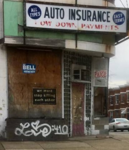 “Tenemos que dejar de matarnos entre nosotros”, reza un cartel pegado a una placa de madera de un comercio tapiado en West Baltimore