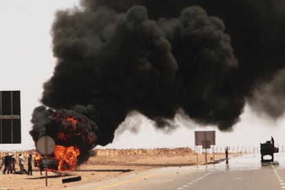 Un vehículo conducido por soldados de Gadafi arde tras ser atacado por los rebeldes, a 138 kilómetros de Sirte.