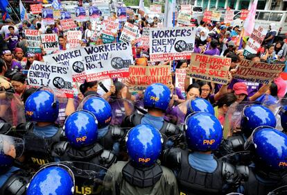 Miembros de la polica impiden el paso a unas mujeres activistas durante una manifestacin contra el presidente estadounidense, DonaldTrump, que finaliza en la embajada estadounidense en Manila, (Filipinas).