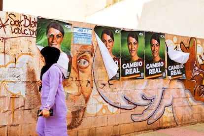 Una mujer con hiyab pasa frente a carteles electorales de Vox en El Ejido (Almería).