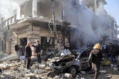 Policías sirios inspeccionan el lugar donde se ha producido un atentado en una zona residencial en Homs (Siria). Al menos 32 personas murieron y otras 90 resultaron heridas en un barrio de mayoría alauí.