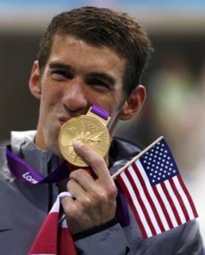 Phelps besa su medalla olímpica.