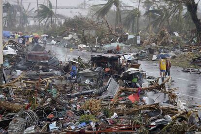 Individuos de la ciudad de Tacloban caminan entre los destrozos causados por el tifón Yolanda.