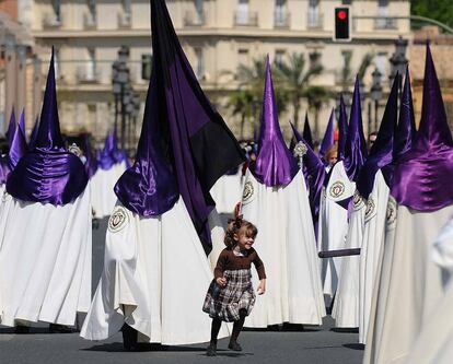 La vistosidad de los atuendos de los cofrades divierte a los más pequeños.