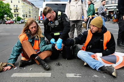 Un agente de policía trata de despegar las manos de dos activistas de Letzte Generation durante una acción de protesta en Berlín el 25 de abril pasado.