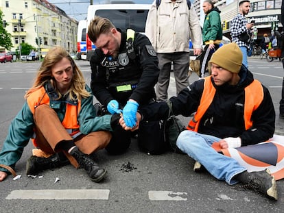 Un agente de policía trata de despegar las manos de dos activistas de Letzte Generation durante una acción de protesta en Berlín el 25 de abril pasado.