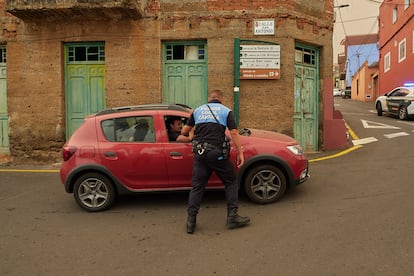 Un agente de la policía local avisa a varios vecino de la evacuación del municipio a causa del incendio, el sábado, en La Victoria.