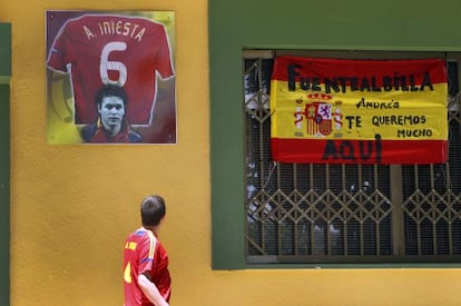 Un turista pasea por delante del bar de la familia de Andrés Iniesta en Fuentealbilla.