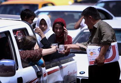 Ciudadanos iraquíes huyen tras la toma de Mosul, segunda ciudad del país. En la imagen, una familia compra agua mientras esperan cruzar el control para acceder a Erbil, capital del Kurdistán iraquí.