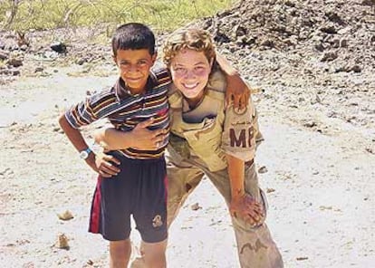 La soldado Sabrina D. Harman posa junto a un niño iraquí en la localidad de Hilla, al sur de Bagdad.