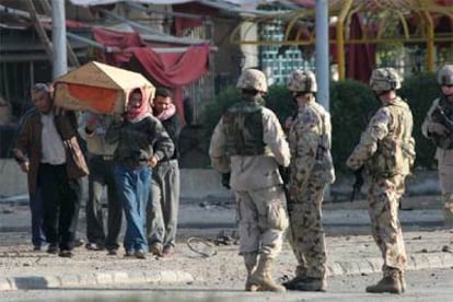 Un grupo de iraquíes se lleva el cadáver de un compatriota muerto en el atentado contra la embajada de Australia.