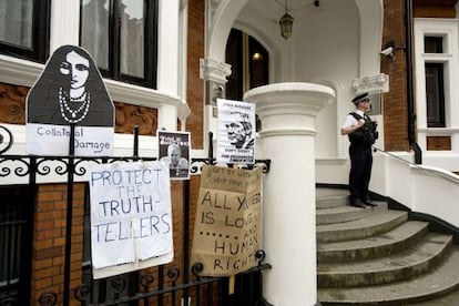 Un policía vigila la embajada ecuatoriana en Londres, donde simpatizantes de Assange han colgado letreros.
