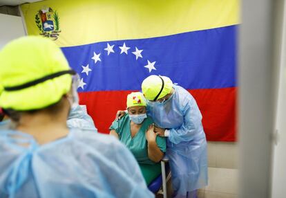 Una trabajadora de salud venezolana acompaña a una colega antes de recibir la vacuna rusa Sputnik V en un hospital en Caracas, Venezuela, este lunes.