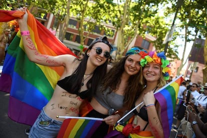 Participantes no desfile do World Pride 2017 posam com a bandeira arco-íris pelas ruas de Madri.