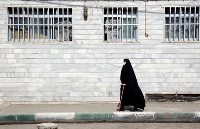 Una mujer pasea por un callejón, al sur de Teherán (Irán). Los medios informaron de que, según el Ministerio de Salud, los muertos por coronavirus pasaron de 10.000 en el país.