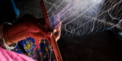 Rohingya refugee, Toyoba, 40, makes a fishing net inside her tent in Kutupalong refugee camp in Ukhia near Cox's Bazar on August 14, 2018. - Ali and his wife Toyota, 40, earns around 6 USD to make one fishing net. Ali sells approximately 3 nets in a month.Nearly 700,000 Rohingya fled Myanmar's Rakhine state last year to escape a violent military crackdown. The United Nations has described the army purge against the persecuted minority as ethnic cleansing, and thousands of Rohingya Muslims were believed to have been slaughtered in the pogrom that began last August. (Photo by CHANDAN KHANNA / AFP)
 
 Una refugiada rohingyá hace una red de pesca en Ukhia (Bangladés).