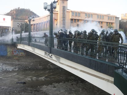Carabineros observan a un manifestante que se encuentra inconsciente tras caer en el río Mapocho, en Santiago (Chile).
