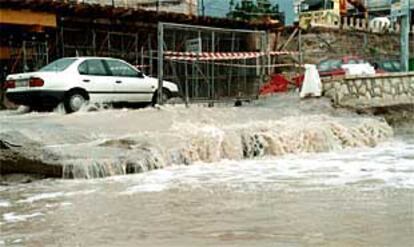 Un coche circula por la zona de L'Albufereta, ayer, inundada por las lluvias.