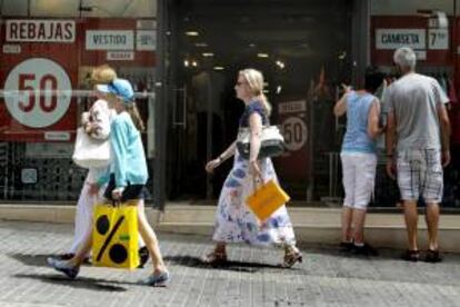 Varias personas pasan ante una tienda en rebajas. EFE/Archivo