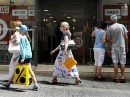 Varias personas pasan ante una tienda en rebajas. EFE/Archivo