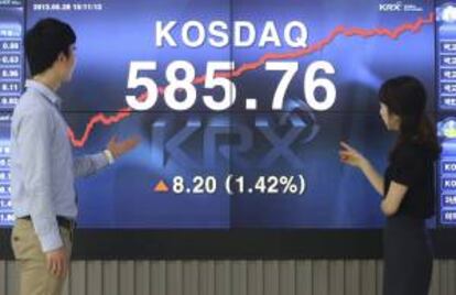 Dos surcoreanos observan en un monitor que muestra los resultados del índice de valores tecnológicos Kosdaq, en la Bolsa de Seúl, en Corea del Sur. EFE/Archivo