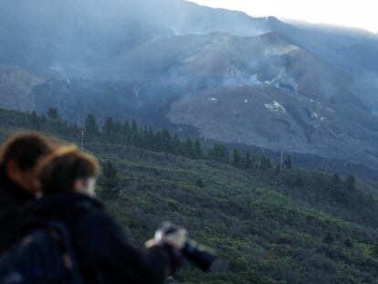 Two tourists in the Tajuya viewpoint take pictures of the Cumbre Vieja volcano without activity in the last few hours