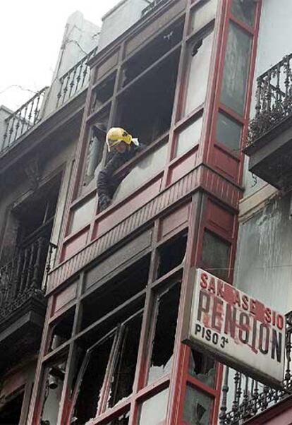 Un bombero inspecciona los pisos incendiados.