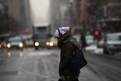 A woman walks across a slushy and icy Manhattan street during frigidly cold weather on February 17, 2015 in New York City. With temperatures in the teens and the wind chill making it feel below zero, New York City is experiencing some of its coldest weather in years. Spencer Platt/Getty Images/AFP == FOR NEWSPAPERS, INTERNET, TELCOS & TELEVISION USE ONLY ==