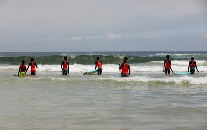 Las alumnas de la escuela Black Girls Surf se meten en el agua del mar que baña la costa de Yoff, en Dakar, Senegal, para una sesión de entrenamiento con la tabla. Son principiantes, pero las aguas de estas playas son muy adecuadas para el aprendizaje de este deporte porque no hay rocas ni corrientes peligrosas.