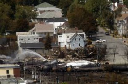 Rescatistas rocían agua sobre unos vagones el 8 de julio de 2013, donde un convoy que transportaba petróleo se descarriló y explotó en la localidad de Lac-Mégantic, Quebec (Canadá). EFE/Archivo