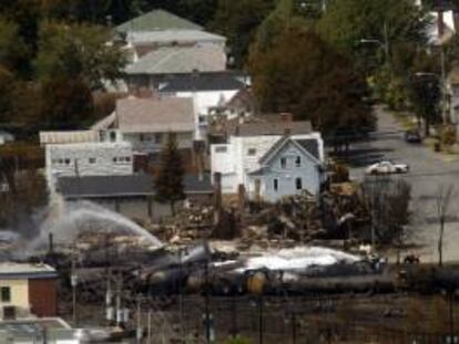 Rescatistas rocían agua sobre unos vagones el 8 de julio de 2013, donde un convoy que transportaba petróleo se descarriló y explotó en la localidad de Lac-Mégantic, Quebec (Canadá). EFE/Archivo