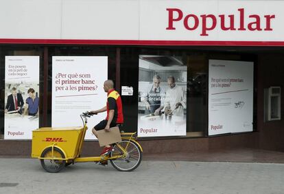 Un repartidor pasa ante una oficina del Banco Popular. EFE/Andreu Dalmau/Archivo