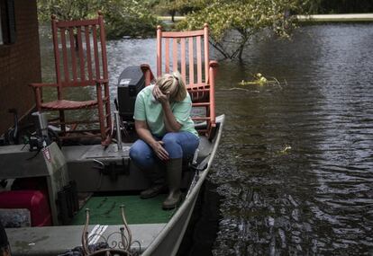 Una mujer muestra su tristeza tras retirar sus pertenencias de su casa inundada tras el paso del huracán.