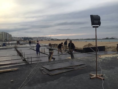 Obreros de la construcción trabajan al anochecer en Tánger en las obras del paseo marítimo, el pasado 17 de abril.